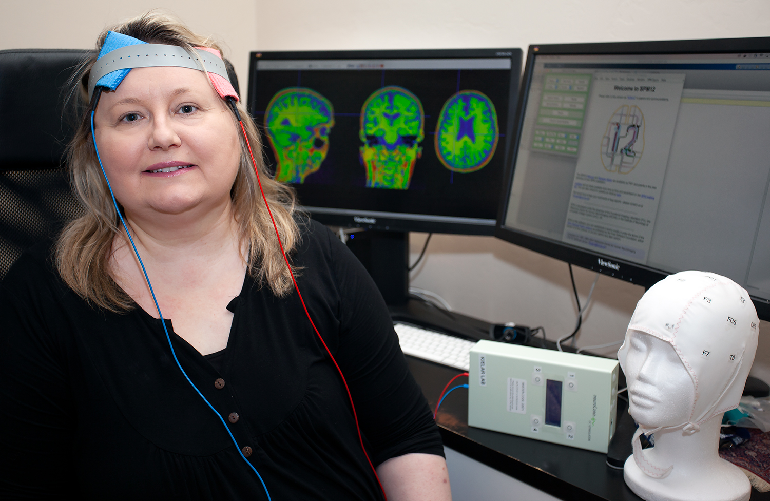 Aneta Kielar with tDCS on and brain images in background