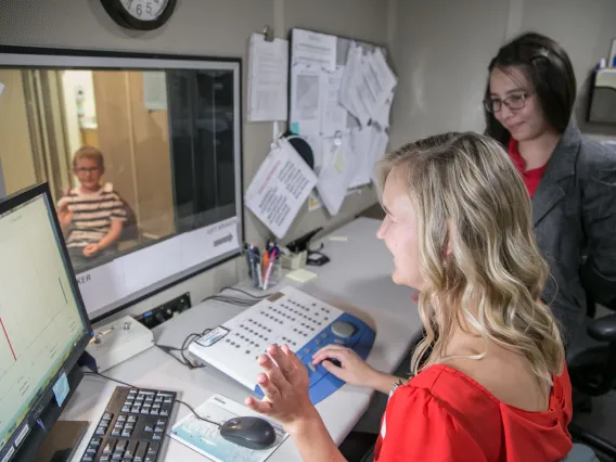 Graduate clinician and instructor completing hearing evaluation on client