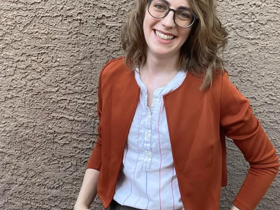 Sarah Lynn smiling standing in front of wall