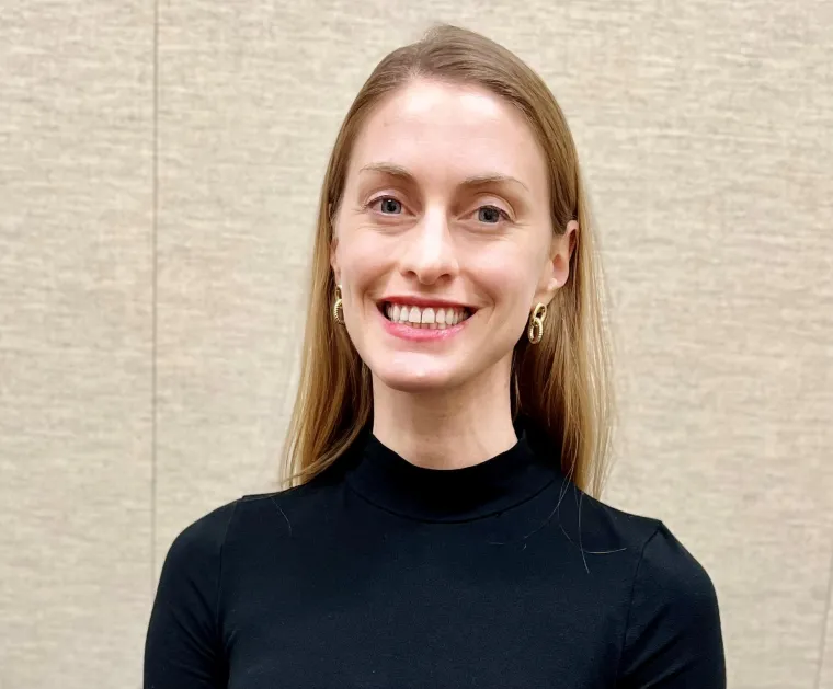 Woman wearing black sweater smiling at camera