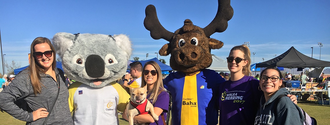 Group of people and people in Koala and Moose mascot outfits.