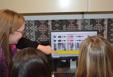 Woman pointing to spectagram on computer screen