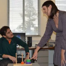 Woman pointing toward a research activity with man smiling