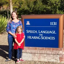 Mother and daughter standing next to SLHS marque. 